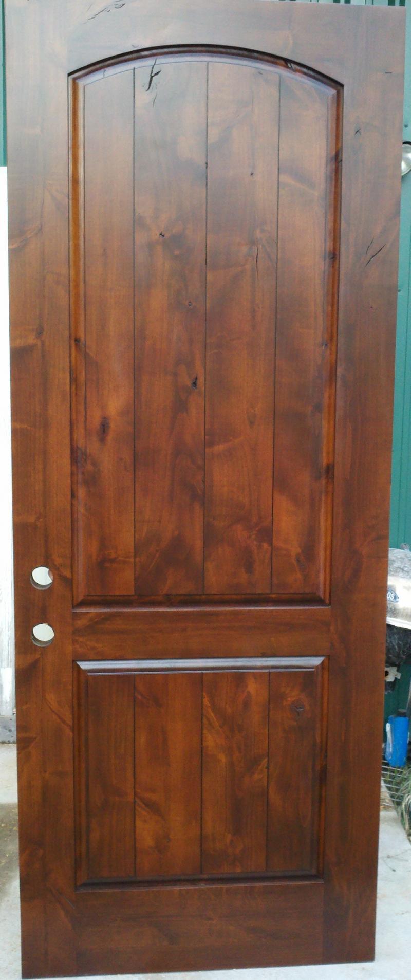 Knotty alder arch top rail raised panel door.