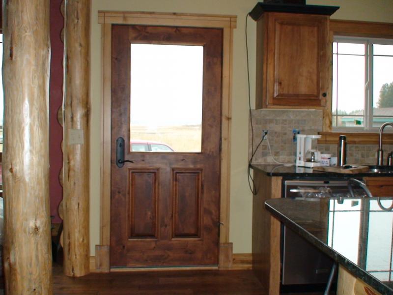 Knotty alder half glass with raised panels and applied moulding