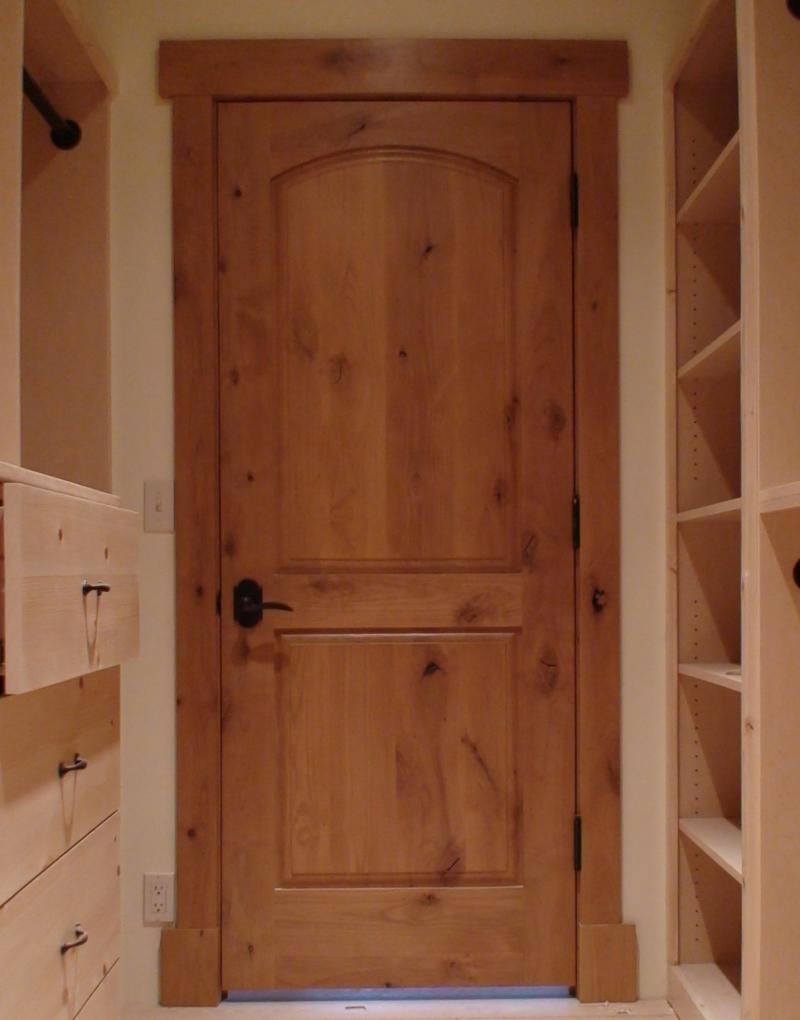 Knotty alder arch top rail raised panel door.